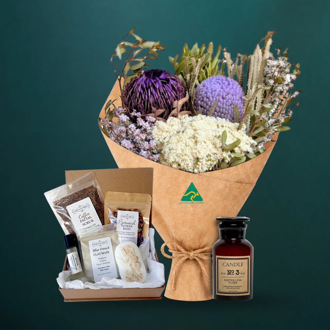 Lilac and purple dried native bouquet with an Australian Flora soy candle and a five-piece Butler Bath pamper set in a kraft gift box, on a dark teal background