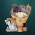 Lilac and purple dried native bouquet with an Australian Flora soy candle and a five-piece Butler Bath pamper set in a kraft gift box, on a dark teal background