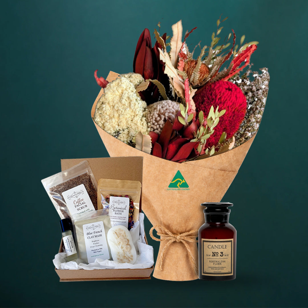 Deep red dried native bouquet with an Australian Flora soy candle and a five-piece Butler Bath pamper set in a kraft gift box, on a dark teal background